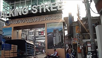 Asian Tourists Explore Walking Street In Pattaya, Thailand During The Day